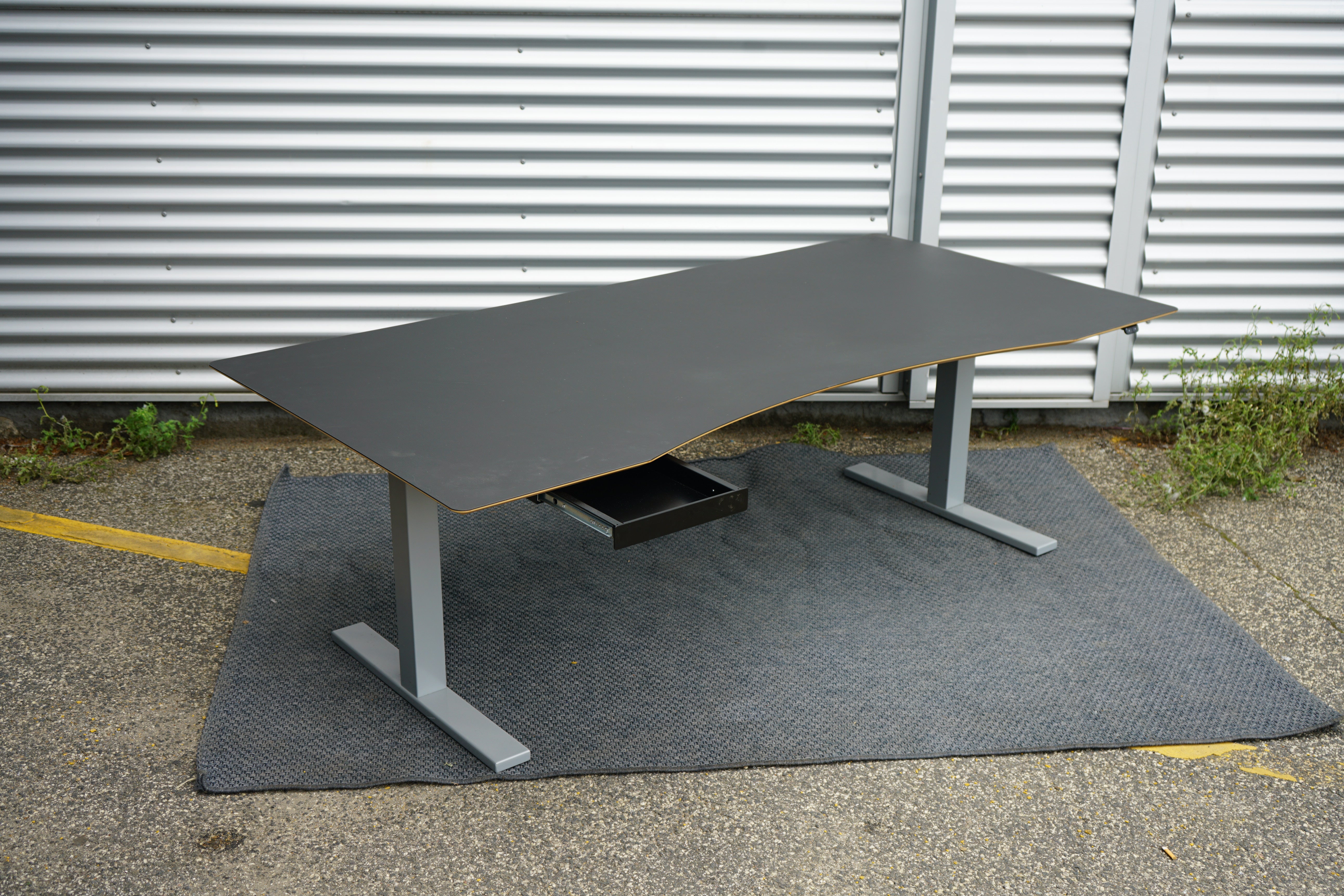 Scanoffice hæve-sænkebord 200x100 cm i sort linoleum med trækant og gråt stel – set fra skrå vinkel